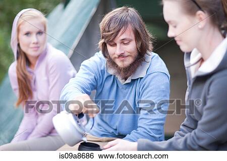 Group of young people sitting outside tent View Large Photo Image Stock Photograph - Group of young people sitting outside tent. Fotosearch