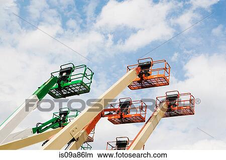 Low angle side view of cherry pickers View Large Photo Image Picture - Low angle side view of cherry pickers. Fotosearch