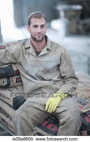 Man sitting on stack of cement bags View Large Photo Image Stock Photography - Man sitting on stack of cement bags. Fotosearch