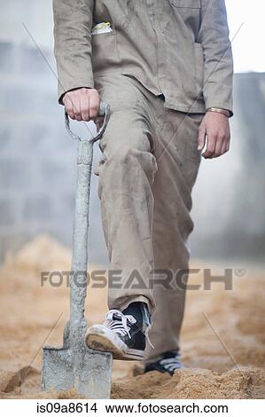 Picture - Man standing with spade. Fotosearch