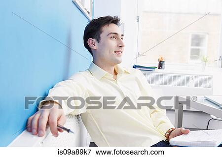 Man wearing shirt sitting in office View Large Photo Image Stock Photo - Man wearing shirt sitting in office. Fotosearch