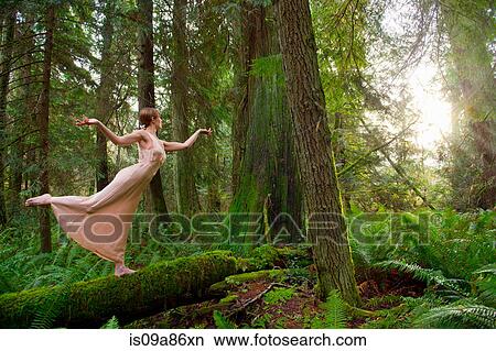 Mature woman standing on log in forest View Large Photo Image Picture - Mature woman standing on log in forest. Fotosearch