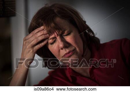 Mature woman with hand on head and eyes closed View Large Photo Image Picture - Mature woman with hand on head and eyes closed. Fotosearch