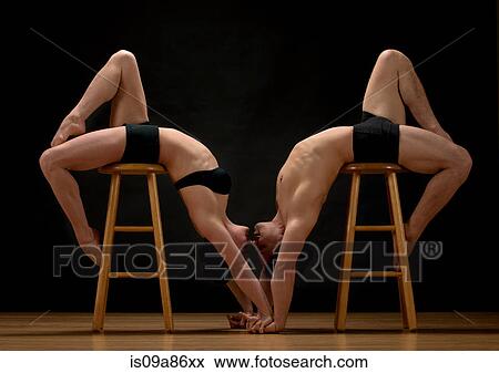 Mid adult dancers bending over stools against black background View Large Photo Image Stock Photo - Mid adult dancers bending over stools against black background. Fotosearch