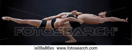 Stock Photo - Mid adult dancers performing together in front of black background. Fotosearch