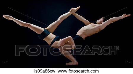 Stock Photo - Mid adult dancers performing together in front of black background. Fotosearch
