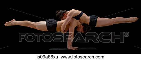 Stock Photograph - Mid adult dancers performing together in front of black background. Fotosearch