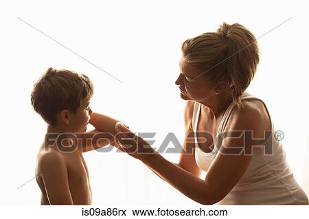 Mother cleaning son's elbow with cotton wool View Large Photo Image Stock Photo - Mother cleaning son's elbow with cotton wool. Fotosearch