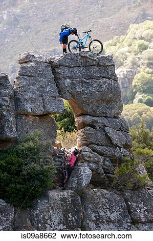 Mountain biking couple on rock formation View Large Photo Image Stock Image - Mountain biking couple on rock formation. Fotosearch