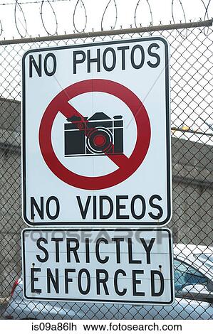 Stock Image - No photography sign on wire fence. Fotosearch