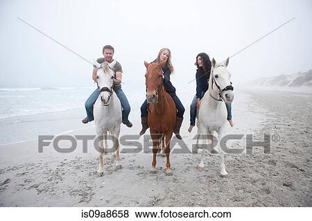 People riding horse on beach View Large Photo Image Stock Photo - People riding horse on beach. Fotosearch