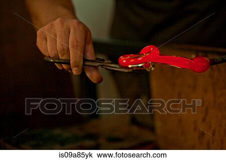 Person holding red hot glass in glass factory View Large Photo Image Stock Image - Person holding red hot glass in glass factory. Fotosearch