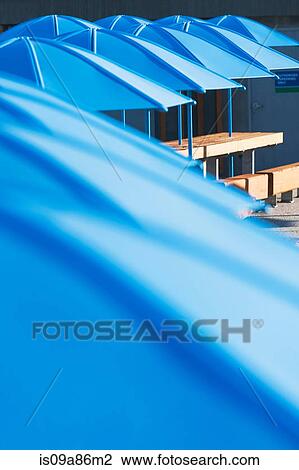 Picnic tables with blue umbrellas View Large Photo Image Stock Image - Picnic tables with blue umbrellas. Fotosearch