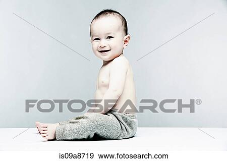 Stock Photo - Portrait of baby boy wearing grey trousers. Fotosearch