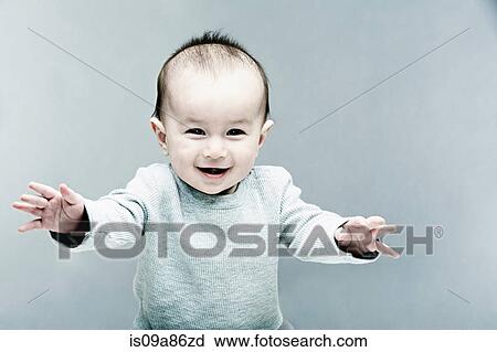 Stock Image - Portrait of baby boy wearing grey top. Fotosearch