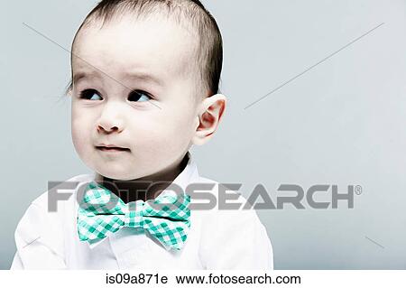 Stock Image - Portrait of baby boy wearing shirt and bow tie. Fotosearch