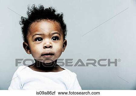 Stock Image - Portrait of baby boy wearing white vest. Fotosearch