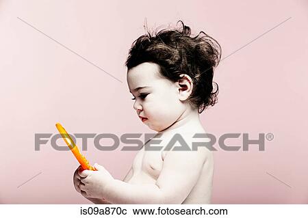 Portrait of baby girl holding plastic toy View Large Photo Image Stock Image - Portrait of baby girl holding plastic toy. Fotosearch