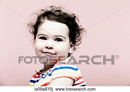Stock Image - Portrait of baby girl wearing striped top. Fotosearch