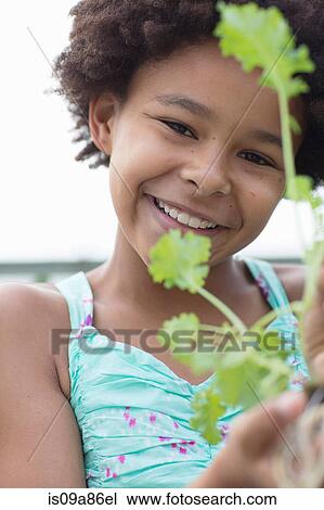 Portrait of girl holding plant View Large Photo Image Stock Image - Portrait of girl holding plant. Fotosearch