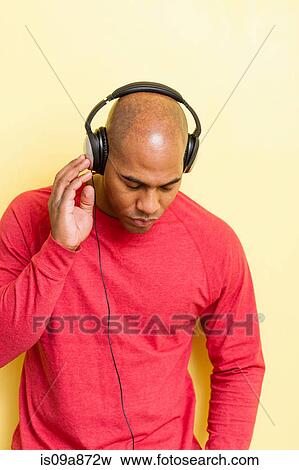 Stock Photo - Portrait of mid adult male eyes closed with headphones. Fotosearch