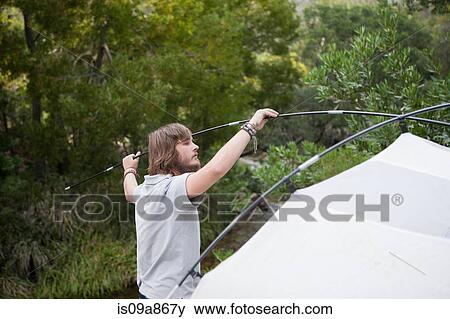 Portrait of young man setting up tent View Large Photo Image Stock Photo - Portrait of young man setting up tent. Fotosearch