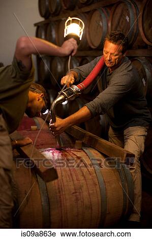 Stock Image - Pumping into barrel of wine. Fotosearch