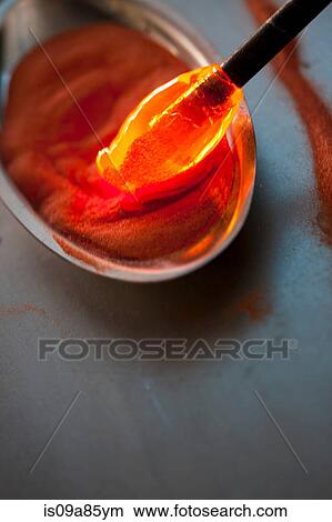 Red hot glass being dipped in sand in glass factory View Large Photo Image Picture - Red hot glass being dipped in sand in glass factory. Fotosearch