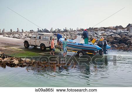 Small group of men landing dinghy onto trailer in harbor View Large Photo Image Stock Image - Small group of men landing dinghy onto trailer in harbor. Fotosearch