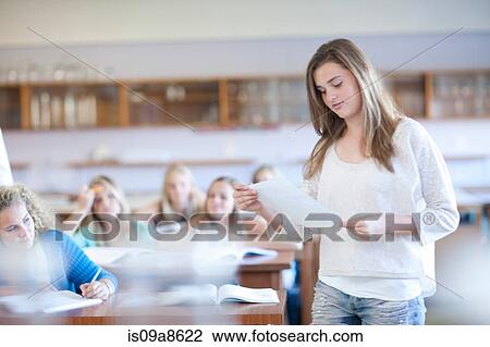 Stock Image - Student standing up to give answer. Fotosearch