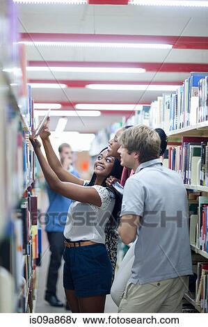Stock Photo - Students choosing books in library. Fotosearch