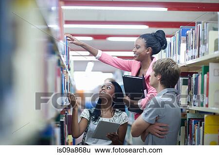 Stock Photograph - Students in library with digital tablet. Fotosearch