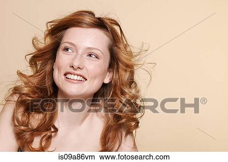 Picture - Studio shot of young woman with curly red hair. Fotosearch