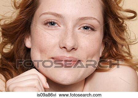 Studio shot of young woman with curly red hair, hand on chin View Large Photo Image Stock Image - Studio shot of young woman with curly red hair, hand on chin. Fotosearch