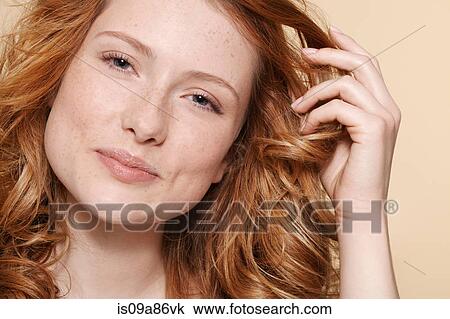 Studio shot of young woman with curly red hair, hand in hair View Large Photo Image Stock Image - Studio shot of young woman with curly red hair, hand in hair. Fotosearch