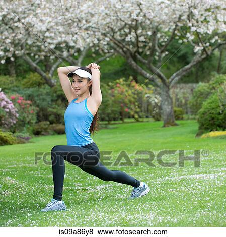 Teenage girl wearing blue sportswear stretching in park View Large Photo Image Stock Photo - Teenage girl wearing blue sportswear stretching in park. Fotosearch