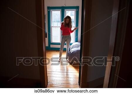 Teenager standing in bedroom listening to MP3 player View Large Photo Image Stock Photo - Teenager standing in bedroom listening to MP3 player. Fotosearch