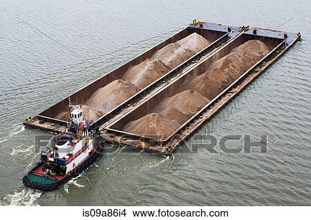 Picture - Tugboat pushing barges of sand, high angle view. Fotosearch