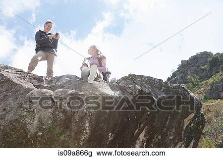 Two girl hikers photographing on top of rock formation View Large Photo Image Stock Image - Two girl hikers photographing on top of rock formation. Fotosearch