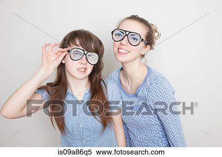 Stock Photography - Two girls wearing fake glasses. Fotosearch