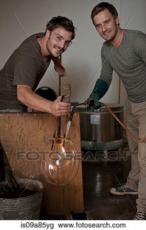 Stock Image - Two men blowing glass. Fotosearch