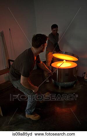 Stock Image - Two men working in glass factory. Fotosearch