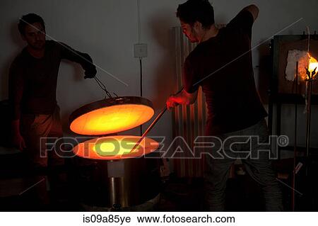 Stock Image - Two men working in glass factory. Fotosearch