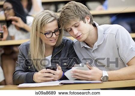 Two students looking at smartphone View Large Photo Image Stock Photo - Two students looking at smartphone. Fotosearch