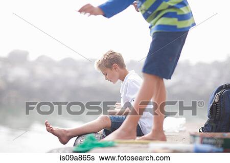Two young boys fishing on pier View Large Photo Image Stock Photograph - Two young boys fishing on pier. Fotosearch