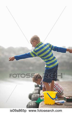 Stock Photography - Two young boys fishing on pier. Fotosearch