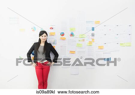 Stock Image - Woman in front of wall with adhesive notes. Fotosearch