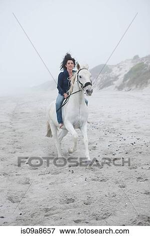 Woman riding horse on beach View Large Photo Image Stock Photo - Woman riding horse on beach. Fotosearch