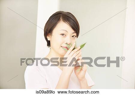Woman smelling leaves View Large Photo Image Picture - Woman smelling leaves. Fotosearch