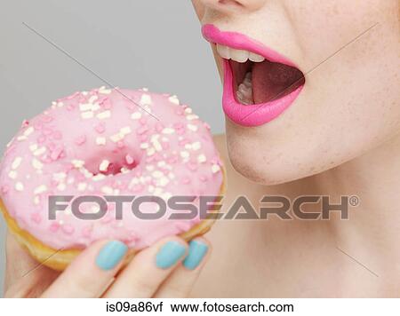 Woman wearing pink lipstick eating doughnut View Large Photo Image Stock Image - Woman wearing pink lipstick eating doughnut. Fotosearch